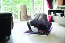 Singaporean Muslim man praying at home.